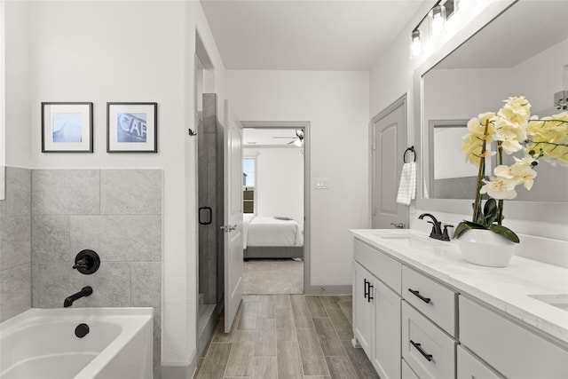 bathroom with plus walk in shower, wood-type flooring, and vanity