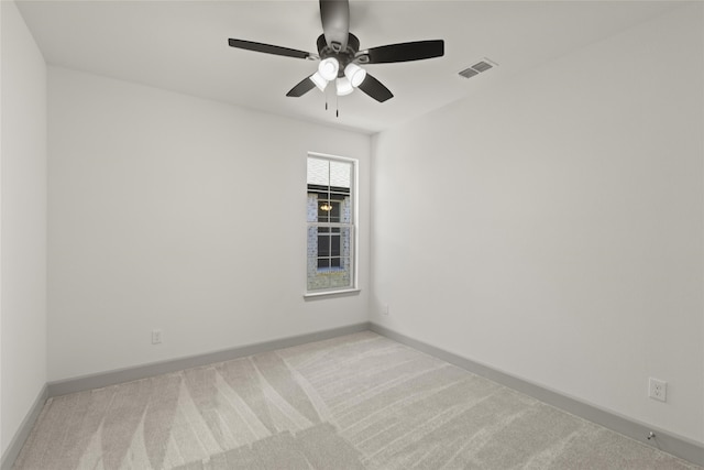 spare room with ceiling fan and light colored carpet