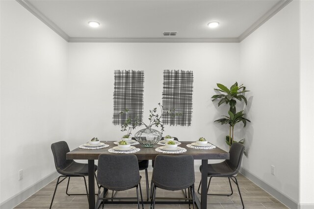 dining room with wood-type flooring and ornamental molding