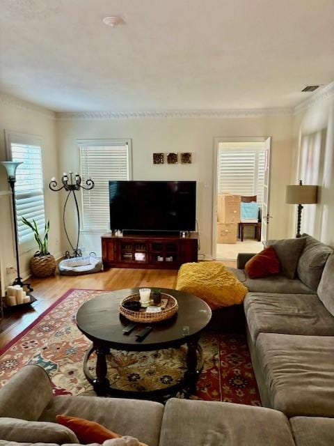 living room featuring ornamental molding and wood-type flooring