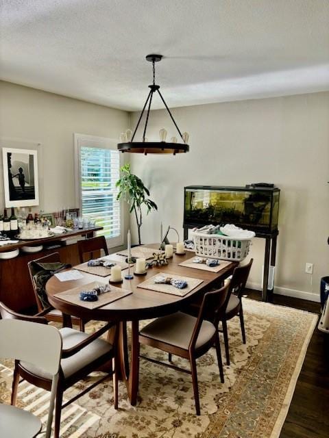 dining area with a textured ceiling and dark hardwood / wood-style flooring