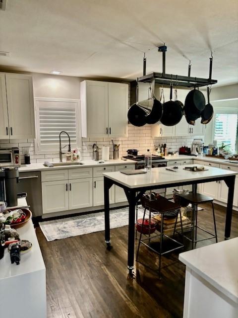 kitchen with white cabinetry, dark hardwood / wood-style floors, sink, and decorative backsplash