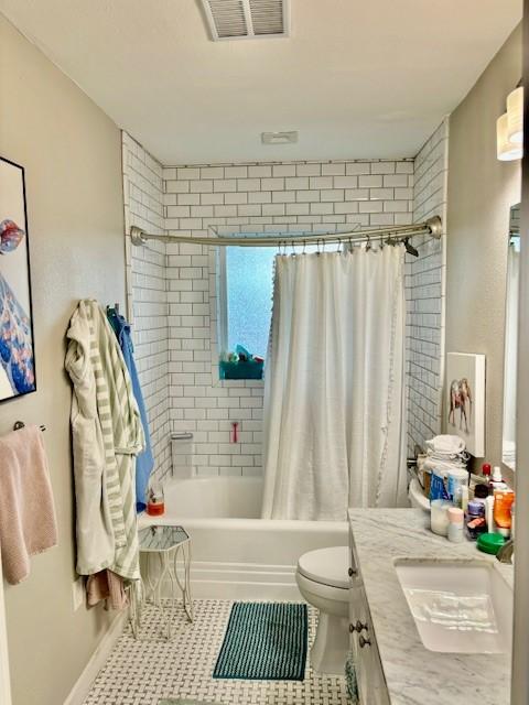 full bathroom with shower / tub combo with curtain, vanity, tile patterned flooring, and toilet