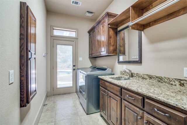 laundry area featuring cabinets, a healthy amount of sunlight, independent washer and dryer, and sink