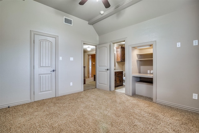 unfurnished bedroom with ceiling fan, a closet, light colored carpet, a walk in closet, and lofted ceiling with beams