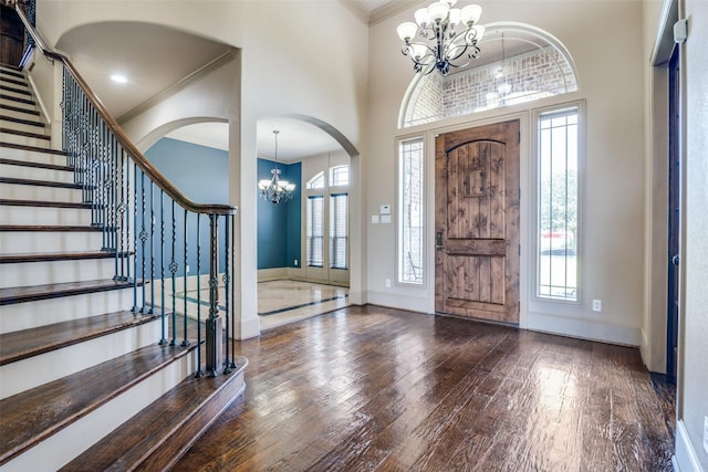 foyer with an inviting chandelier, crown molding, and plenty of natural light