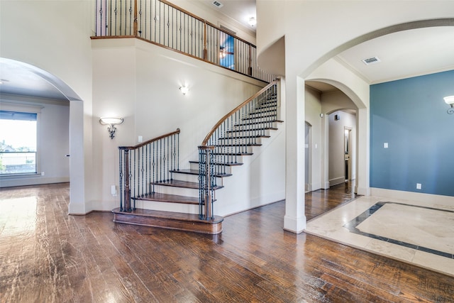 entrance foyer with ornamental molding and hardwood / wood-style flooring