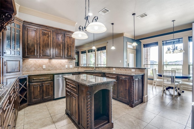 kitchen with hanging light fixtures, stainless steel dishwasher, dark brown cabinetry, and a kitchen island