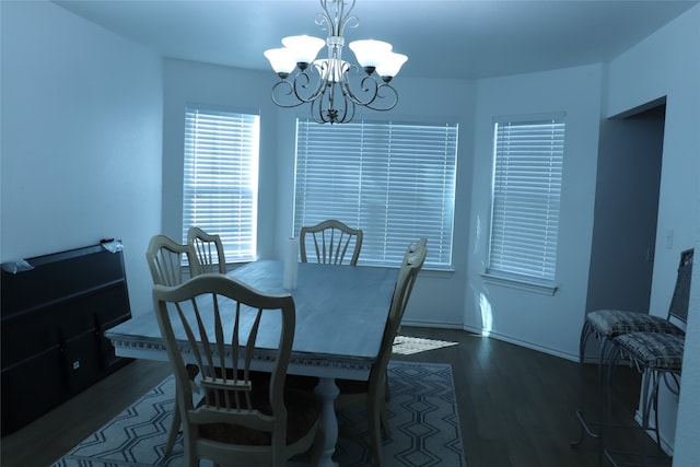 dining room with dark wood-type flooring and a notable chandelier