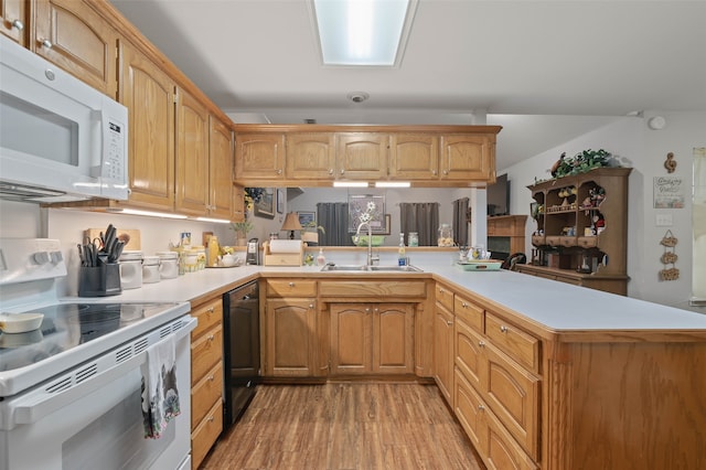 kitchen featuring sink, light hardwood / wood-style flooring, kitchen peninsula, and white appliances