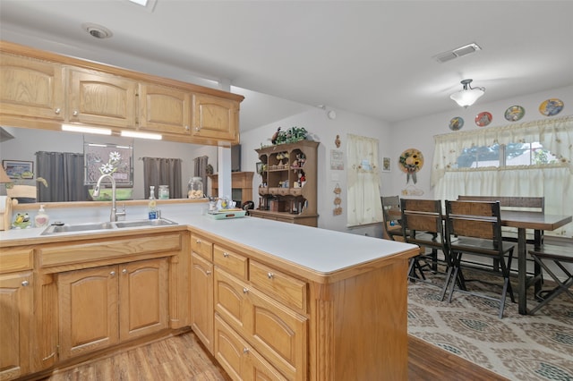 kitchen featuring sink, kitchen peninsula, and light hardwood / wood-style floors