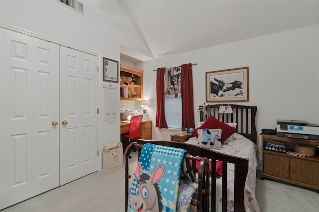 bedroom with a closet, lofted ceiling, and light colored carpet