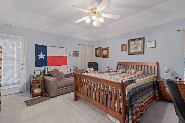 bedroom featuring carpet floors, a tray ceiling, and ceiling fan