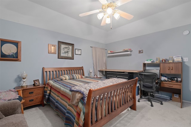 carpeted bedroom with a tray ceiling and ceiling fan