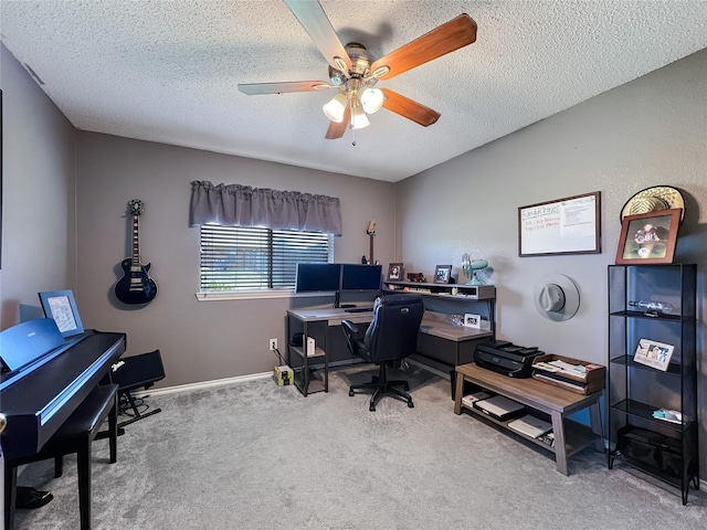 carpeted home office with ceiling fan and a textured ceiling