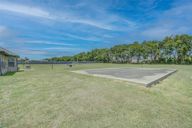 view of home's community with basketball court and a lawn