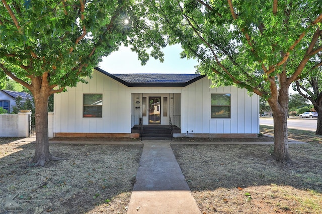 view of front facade with board and batten siding and a shingled roof