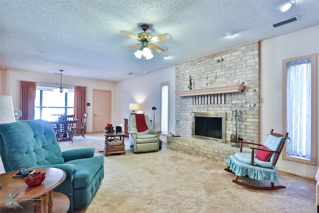 carpeted living room with a fireplace, a textured ceiling, and ceiling fan with notable chandelier