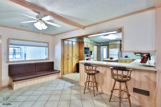 kitchen featuring a breakfast bar, oven, and a textured ceiling