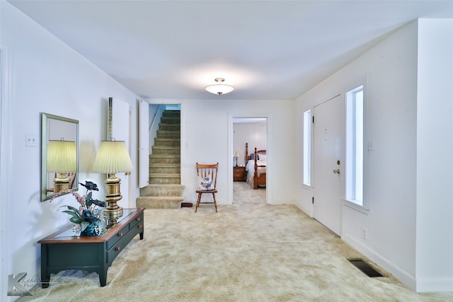 foyer entrance featuring carpet floors