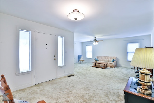 living room with carpet flooring, a wealth of natural light, and ceiling fan