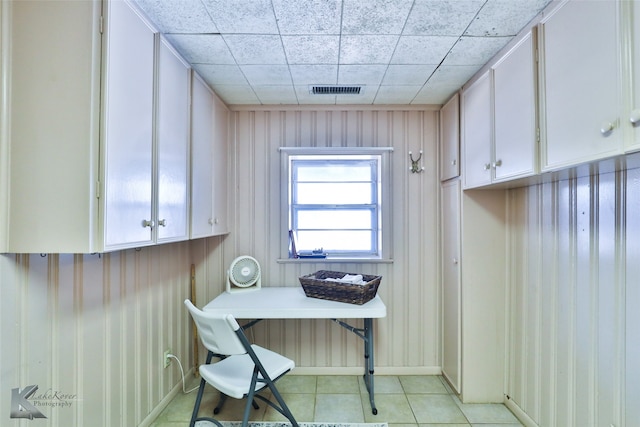 home office with a paneled ceiling and light tile patterned floors