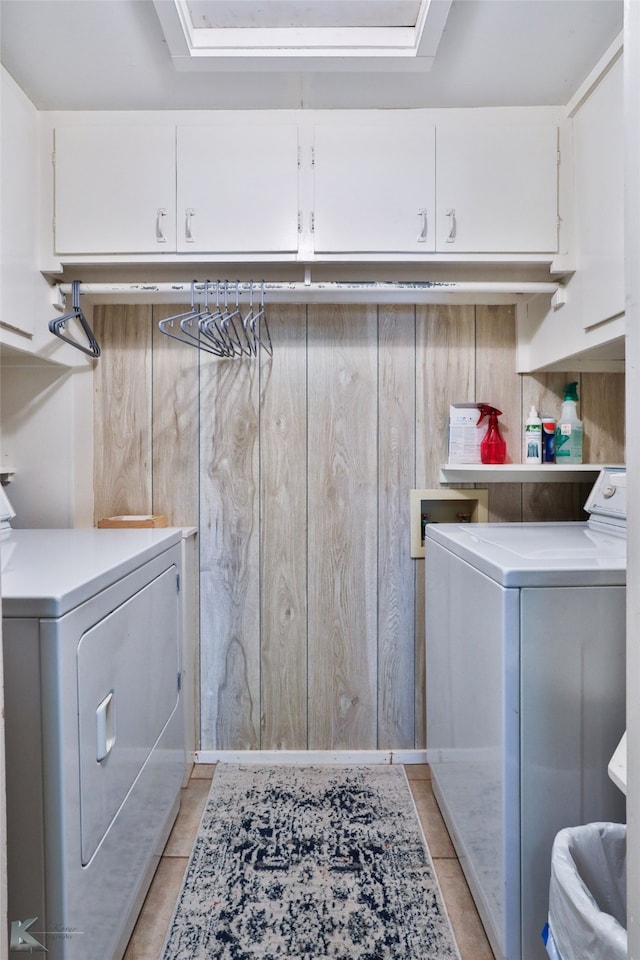 washroom featuring washer and dryer, light tile patterned flooring, and cabinets