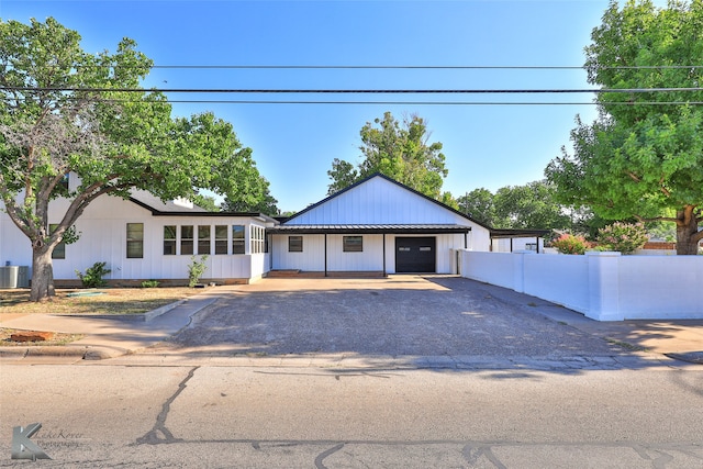 view of front of home featuring a sunroom, cooling unit, and a garage