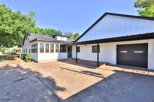 view of front of property with a garage and a sunroom