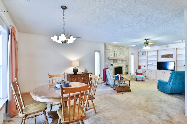 carpeted dining room featuring a textured ceiling, ceiling fan with notable chandelier, and a brick fireplace