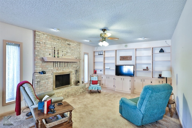 carpeted living room featuring ceiling fan, a textured ceiling, a wealth of natural light, and a brick fireplace