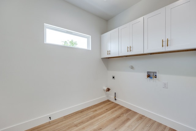 laundry area featuring light hardwood / wood-style flooring, hookup for a washing machine, hookup for a gas dryer, cabinets, and electric dryer hookup