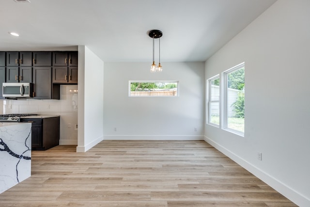 unfurnished dining area featuring light wood-type flooring