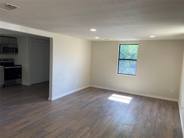 spare room with dark wood-type flooring and a textured ceiling