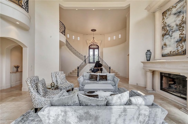 living area featuring stairs, a high ceiling, a tiled fireplace, and arched walkways