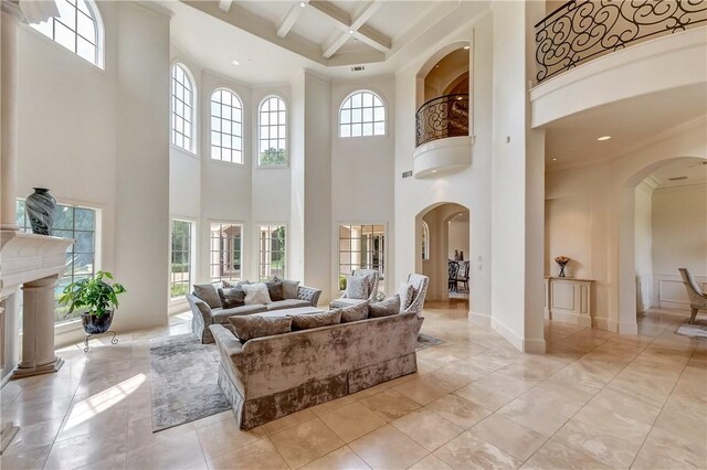 living room featuring beamed ceiling, coffered ceiling, light tile patterned floors, and a towering ceiling