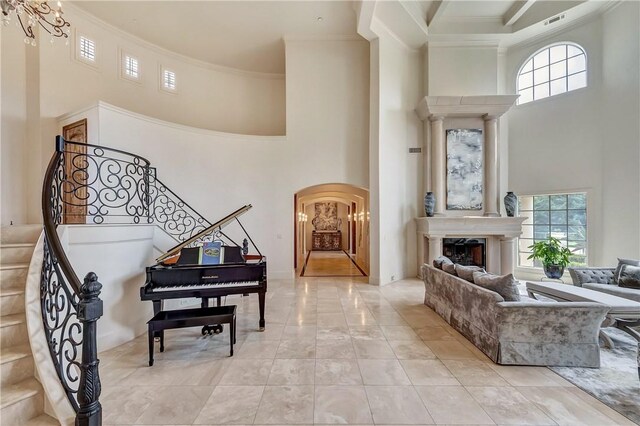 interior space with light tile patterned floors, a towering ceiling, and a wealth of natural light