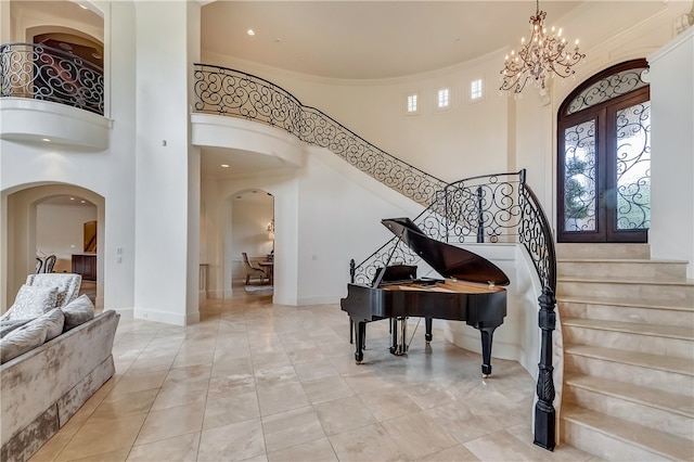 miscellaneous room with light tile patterned flooring, crown molding, an inviting chandelier, french doors, and a towering ceiling