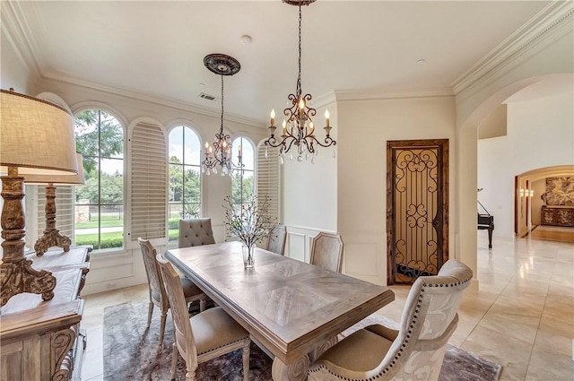 dining space featuring arched walkways, light tile patterned floors, visible vents, ornamental molding, and wainscoting