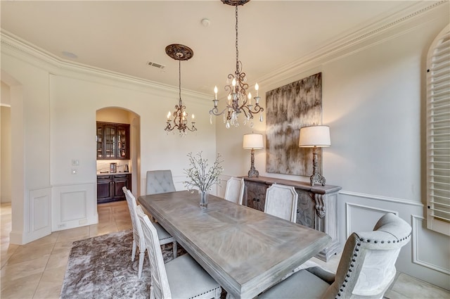 tiled dining space with crown molding and a chandelier