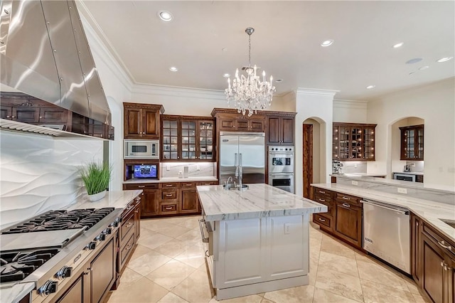 kitchen with built in appliances, ventilation hood, a center island with sink, and glass insert cabinets