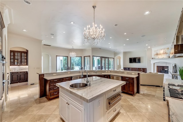 kitchen featuring white cabinetry, light tile patterned floors, an island with sink, pendant lighting, and sink