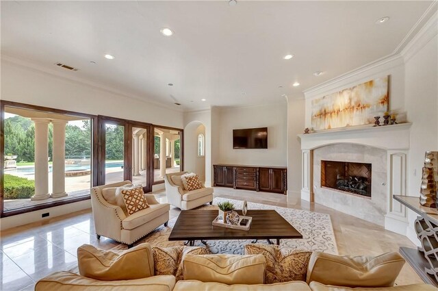 tiled living room with ornamental molding, ornate columns, and a fireplace