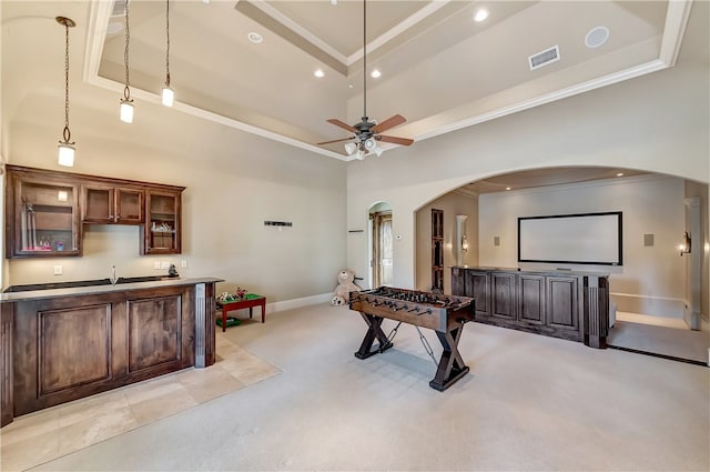 game room featuring ceiling fan, a raised ceiling, and crown molding