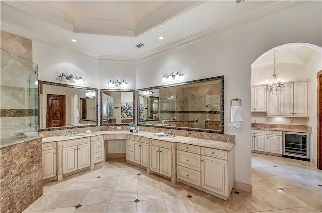 bathroom featuring a notable chandelier, ornamental molding, a raised ceiling, wine cooler, and tile patterned flooring