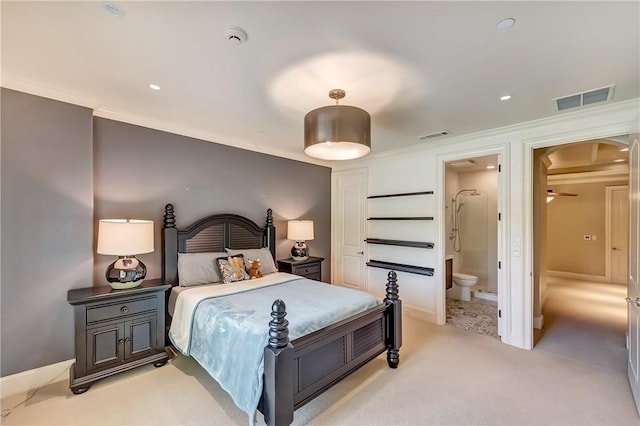 bedroom with ensuite bath, visible vents, crown molding, and light colored carpet