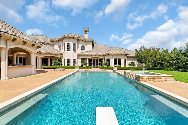 view of pool featuring a diving board, a patio, exterior bar, and a pool with connected hot tub