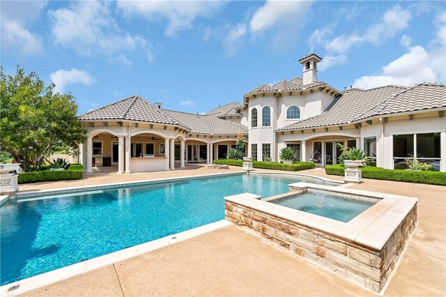 view of swimming pool featuring a patio and an in ground hot tub