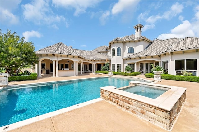 view of pool with a pool with connected hot tub and a patio