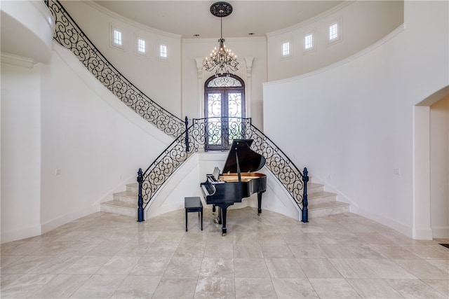 interior space featuring a notable chandelier, ornamental molding, light tile patterned floors, and a towering ceiling